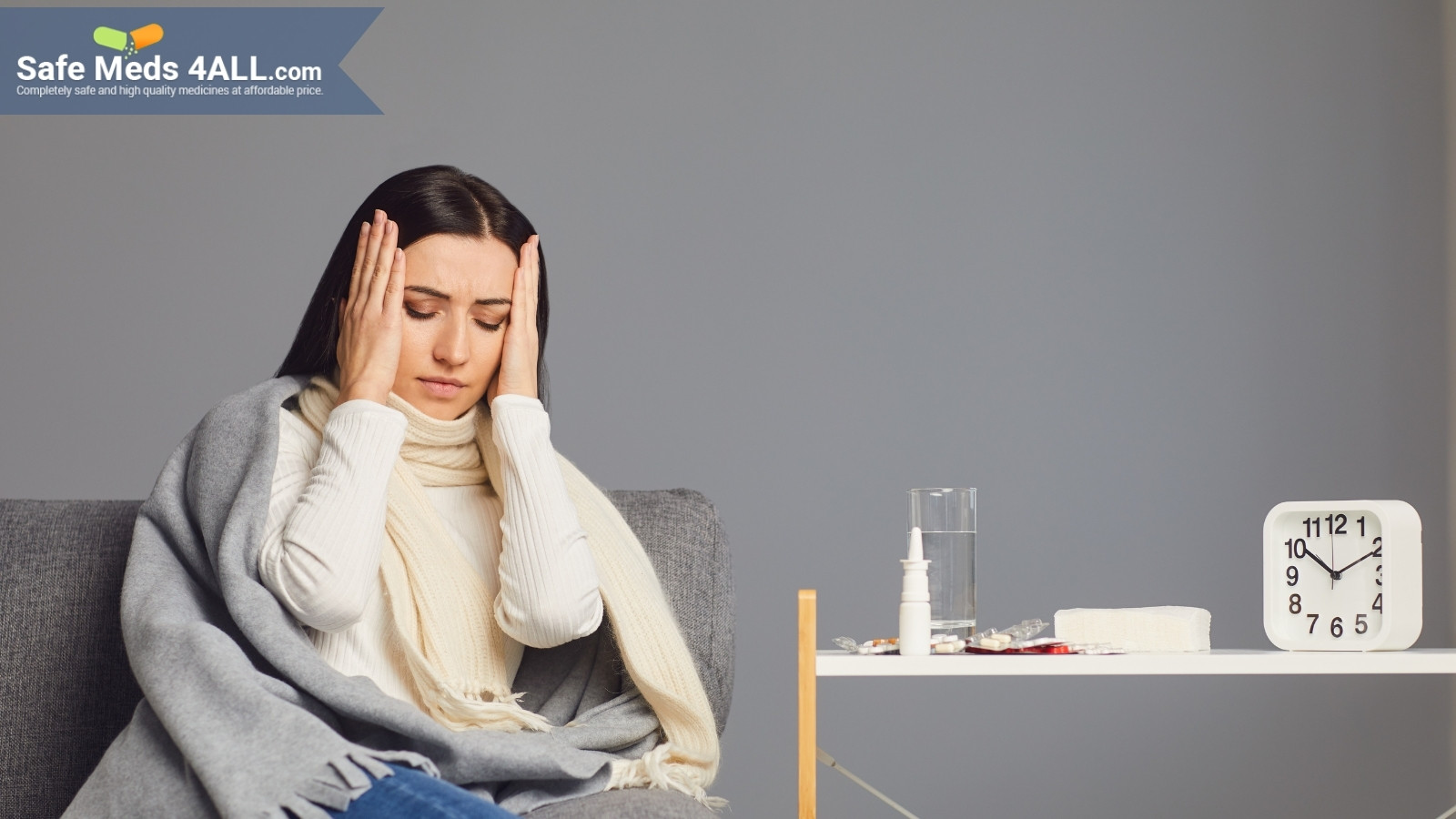 A girl sitting on a chair and holding her head in pain.