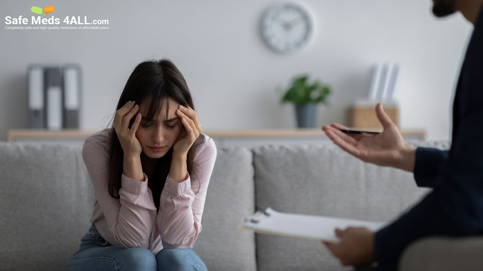 A woman sitting on the couch with her head held in distress