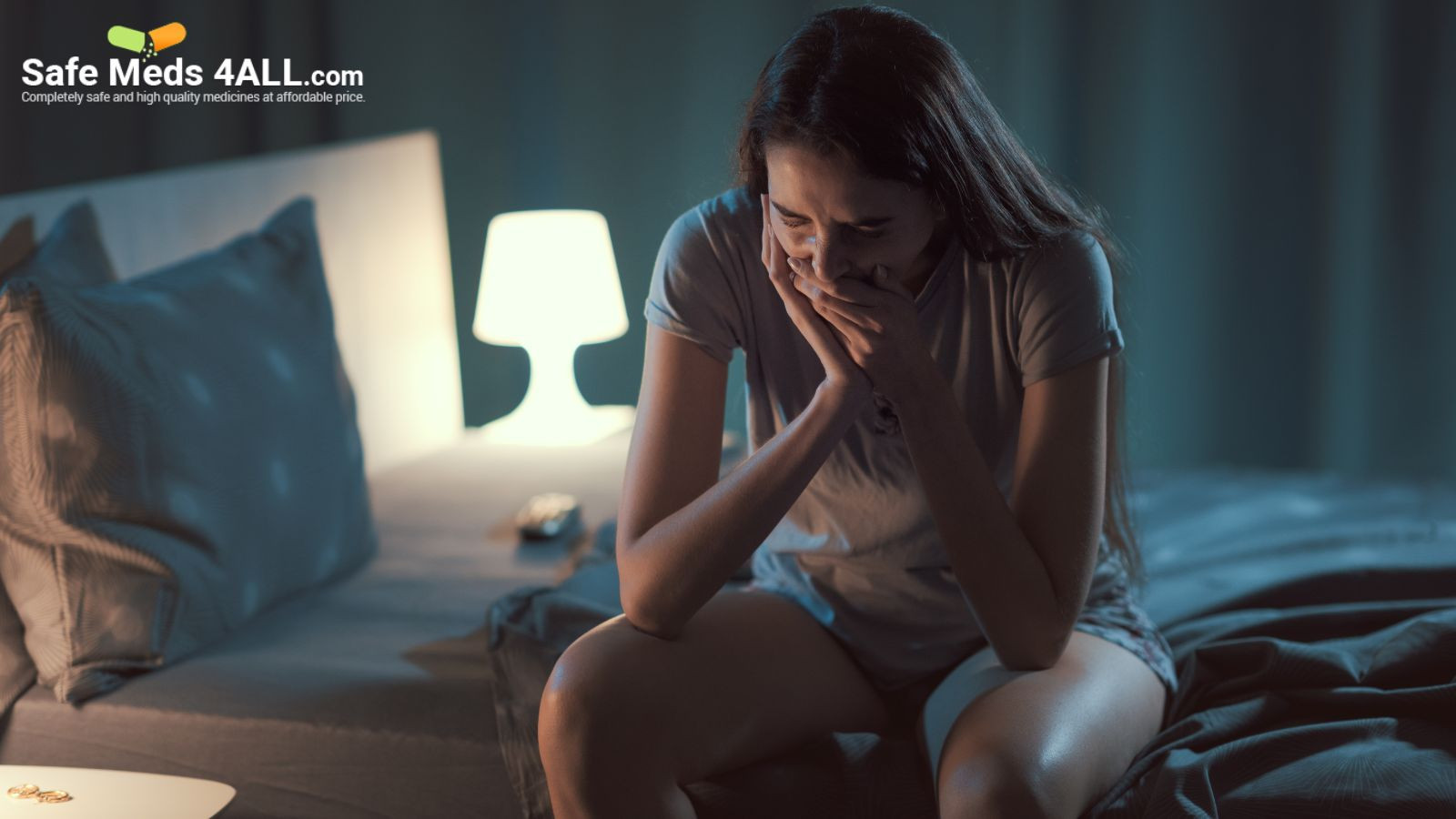 A girl sitting stressed on her bed  with her hands holding her face.