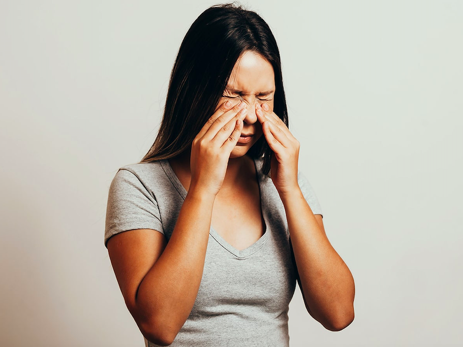 Girl pressing her eyes and nose area