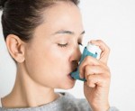 Woman using asthma inhaler